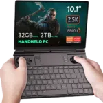 GPD Win Max 2 (2024) er vist med spillet The Witcher på skjermen. Enheten har imponerende spesifikasjoner, inkludert opptil 64 GB RAM, opptil 4 TB SSD NVMe-lagring og en Ryzen 7 8840U-prosessor, noe som fremhever dens evne til å håndtere krevende spill med letthet.