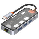 This is an image of a USB-C hub with multiple ports and a visible internal circuit board. The hub features several USB-A ports, an Ethernet port, and another USB-C port. The casing is transparent on top, allowing the internal components to be visible. The USB-C cable attached to the hub has a metal connector with an orange accent near the plug. This hub appears to be a multi-functional accessory for devices like laptops or tablets, offering additional connectivity options. The Ethernet port is located on one end of the device, and the USB-A ports are aligned along the side.